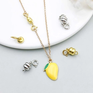 Dettaglio del ciondolo a mango smaltato oro con chiusura magnetica e moschettone a molla