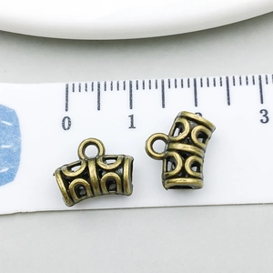 Detailed view of bronze alloy spacer bead with hollow patterns measured on a white scale