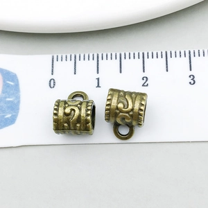 Detail of vintage bronze alloy tube charms with 10mm length scale for jewelry making