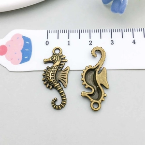 Detail of 3cm vintage bronze seahorse charms showing embossed texture and dimensions