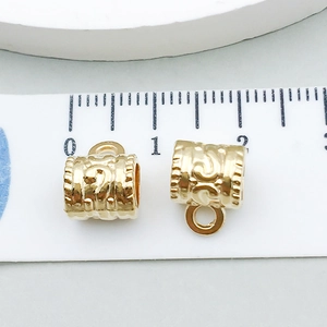 Vista macro de cuentas espaciadoras de aleación oro KC con medida de 10mm en regla