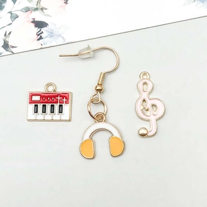 Detailed view of enamel music charms including keyboard, yellow headphones and pink treble clef