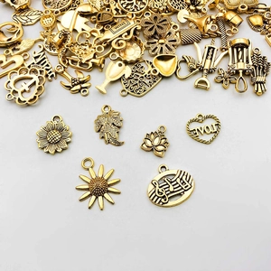 Nahaufnahme goldener Legierungsanhänger mit Sonnenblumen, Lebensbaum und Herzmotiven