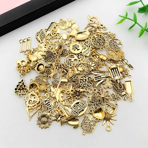 Makroaufnahme von antiken Goldlegierungsanhängern mit Lebensbaum- und Sonnenblumendesign