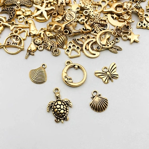 Dettaglio di ciondoli in lega d'oro vintage con tartaruga, conchiglia e farfalla