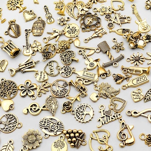 Detailaufnahme goldener Legierungsanhänger mit Lebensbaum und Musikinstrument-Motiven