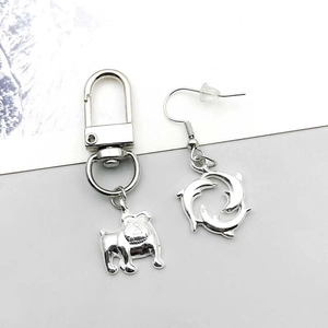 Detailed view of silver bulldog keychain and dolphin earrings jewelry accessories