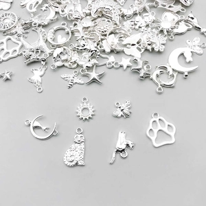 Macro view of silver alloy pendants in moon, star, and animal shapes for DIY jewelry making