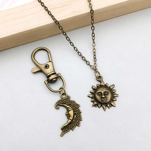 Detailansicht von antikem Bronze-Set aus Sonnen-Halskette und Mond-Schlüsselanhänger