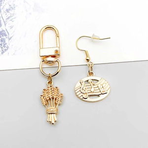 Détails macro d'un pendentif en épi de blé doré et de boucles d'oreilles musicales