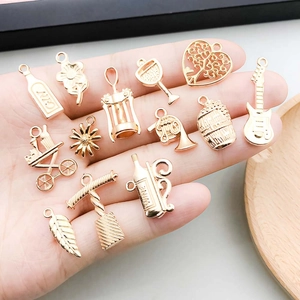 Lot de breloques DIY or rose avec motifs de rose et d'arbre tenus dans la paume