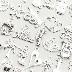 Macro shot of assorted silver alloy charms including musical instruments and plants