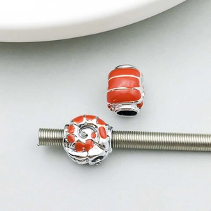 Detail of orange and silver alloy charms featuring enamel finish for DIY jewelry