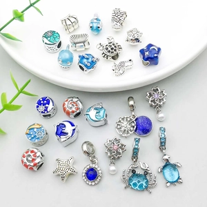 Flat lay of alloy ocean charms with colorful enamel sea stars, turtles and seahorse beads