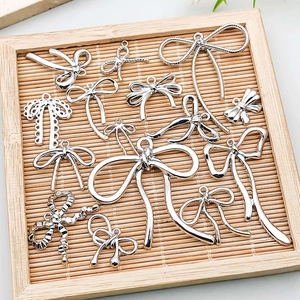 Detailed view of assorted silver alloy bow pendants for DIY jewelry making and bracelets