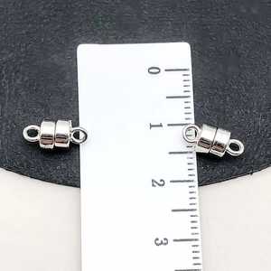 Detailed macro view showing a 10mm silver magnetic jewelry clasp with scale comparison