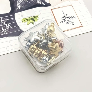 DIY jewelry charm set with assorted metal shapes and colors in a clear storage box