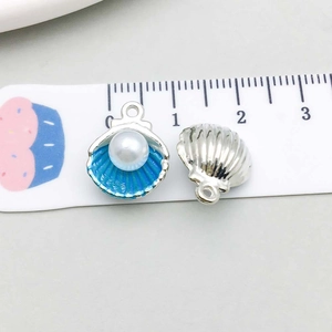 Détail du pendentif coquillage de 1,5cm avec émail bleu et une perle synthétique