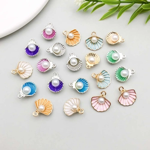 Vue à plat de breloques en coquillage colorées avec perles pour création de bijoux DIY