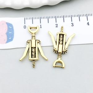 Dettaglio di ciondoli apribottiglie in oro vintage con righello per la misurazione