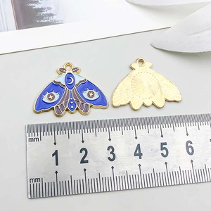 Detail view of moth enamel pendant dimensions with ruler showing 30mm width