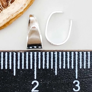 Macro-opname van zilveren hangerclips met liniaal voor het meten van DIY-sieradenonderdelen