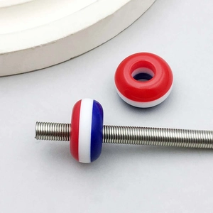 Macro view of colorful resin striped large hole beads mounted on a steel spring rod