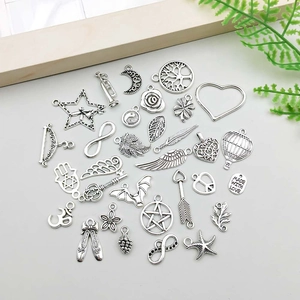 Detailed collection of vintage silver alloy charms including wings and hot air balloon motifs
