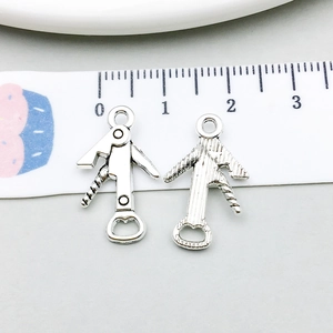 Macro view of silver wine opener charms showing front and back details for jewelry DIY
