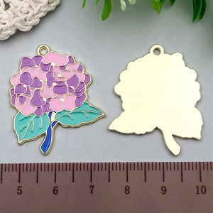 Detailed view of enamel hydrangea pendant with pink gradient petals and gold plating