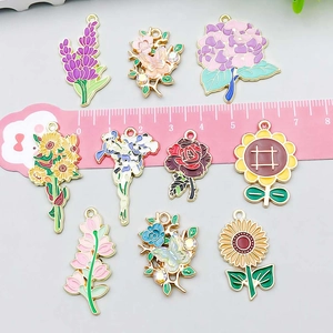 Enamel sunflower and floral alloy pendants for DIY jewelry making shown with ruler