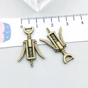 Vue détaillée de breloques tire-bouchon en bronze antique avec règle montrant la taille