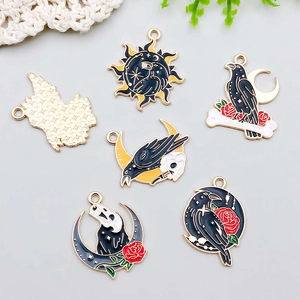 Detailed view of Gothic moon and raven enamel pendants for DIY jewelry making