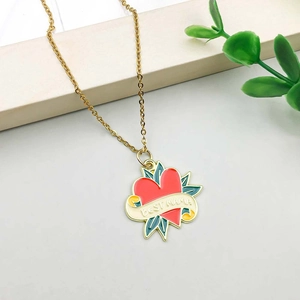 Detail of gold O-chain necklace with a red enamel heart pendant and Best Mama engraving