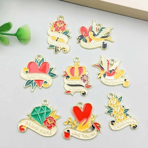 Flat lay of Mother's Day gold enamel charms with flowers, hearts, and MAMA lettering