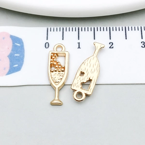 Macro view of gold wine glass charms showing front liquid details and back texture