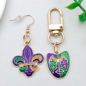 Détails de boucles d'oreilles fleur de lys et porte-clés masque de Mardi Gras à paillettes