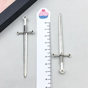 Detailed view of vintage silver sword pendants with ruler showing 8.2cm length