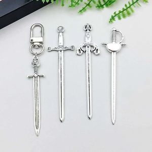 Macro view of medieval vintage silver alloy sword pendants and miniature dagger charms