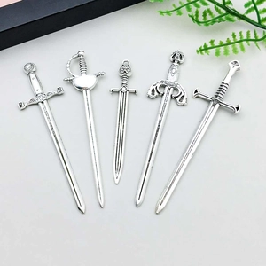 Macro shot of five vintage silver sword charms including a gladiator engraved hilt design