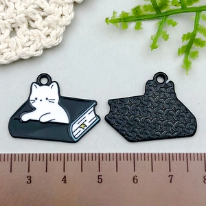 Detail showing the front and back of cat-shaped enamel charms for DIY jewelry making