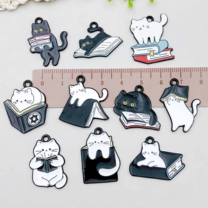 Enamel black and white cat book charms for DIY jewelry making with ruler scale reference