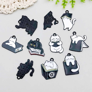 Detail of 7 cute black and white enamel cat and book charms for DIY jewelry making