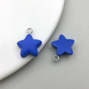 Detail of dark blue matte resin star pendants with silver metal rings for DIY jewelry