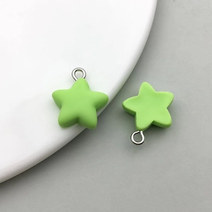 Detail of two light green frosted resin star pendants with silver rings for DIY jewelry