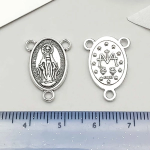 Detail of silver religious charms featuring Virgin Mary and cross motifs with Italy mark