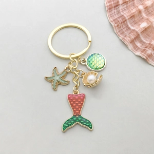 Détail du porte-clés sirène avec pendentifs étoile de mer et coquillage sur perle