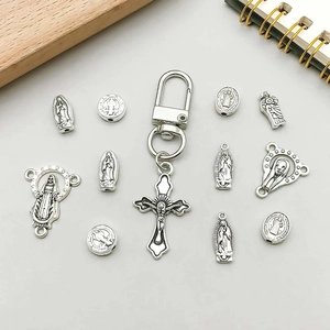 Detail of silver religious cross pendants and Saint Benedict charms for DIY jewelry making