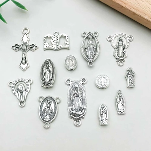 Detail view of assorted vintage silver religious cross and Mary charms for DIY jewelry