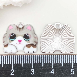 Vue macro d'un pendentif chat en émail coloré de 2,5 cm avec échelle de mesure précise